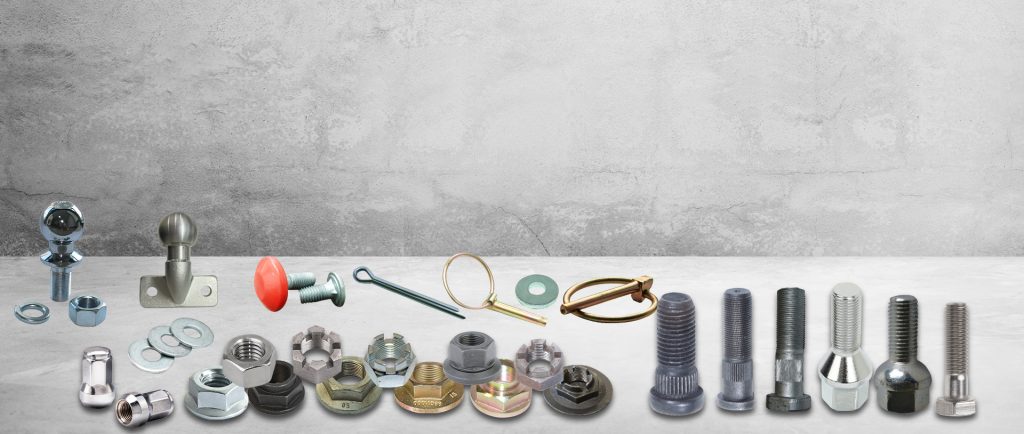 Assorted metal fasteners including bolts, screws, anchors, washers, and nuts arranged on gray surface